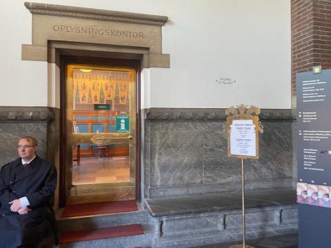 Entrance through this door into the room where you will present your documents