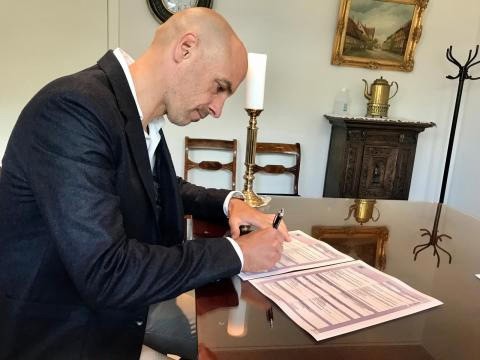 the happy groom signing the international marriage certificate
